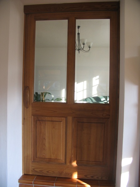 Posunovací dveře z jasanu s fazetovým sklem. dveře se zasunují za nábytkovou stěnu. Povrch je namořen a ošetřen olejem.